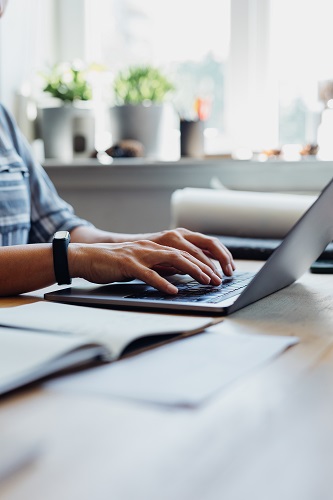 Close up Shot of an Anonymous Young Businesswoman Using a Laptop while Working from Home
