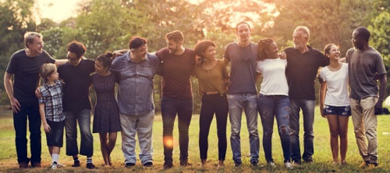 Partners standing in a grassy field in a line arms around each other