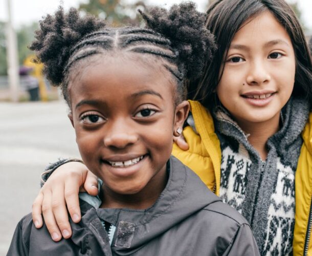 Children standing on a playground smiling