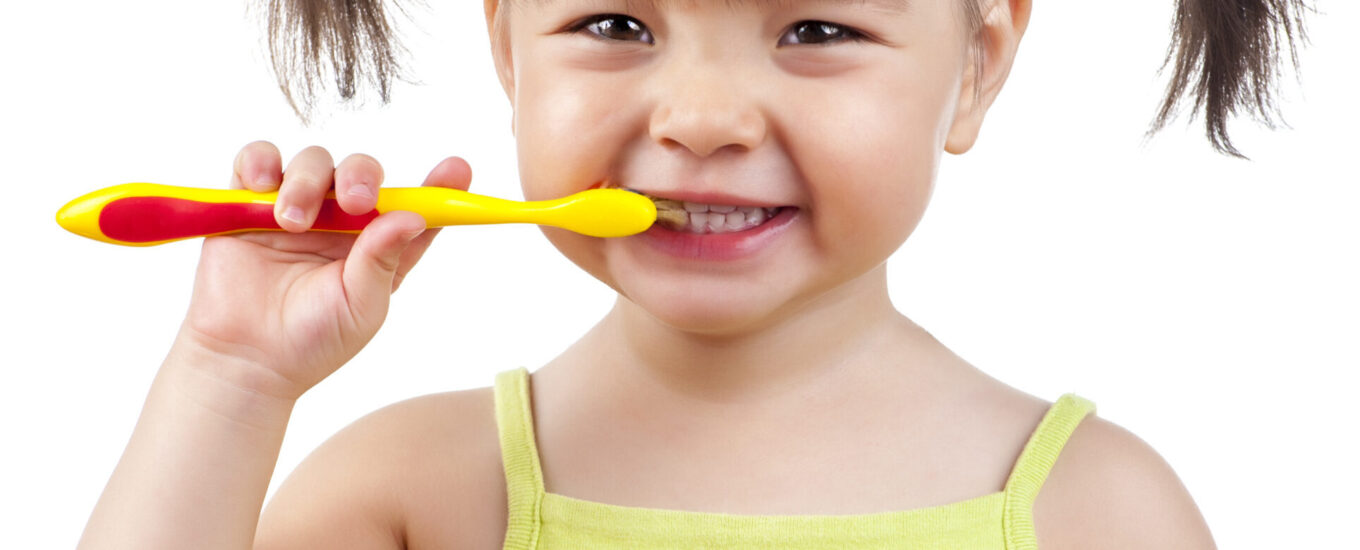 Child holding toothbrush and smiling